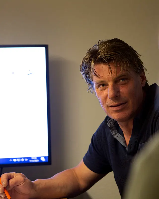 Een man bespreekt een badkamerontwerp op een beeldscherm