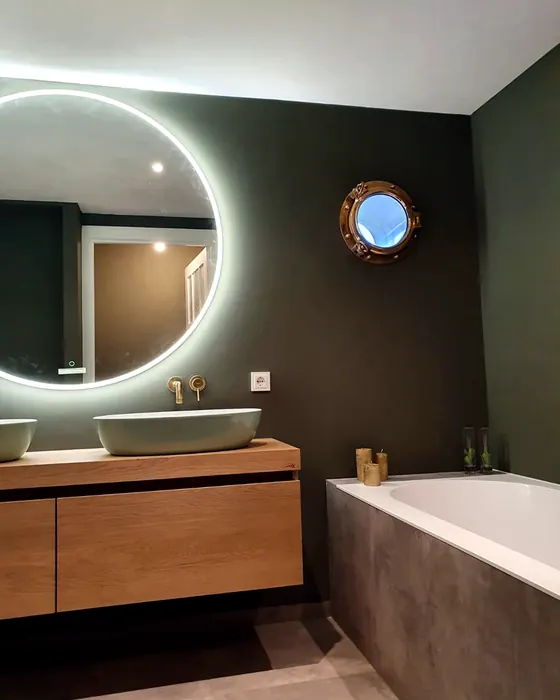 Badkamer met ronde verlichte spiegel, houten badmeubel en ligbad